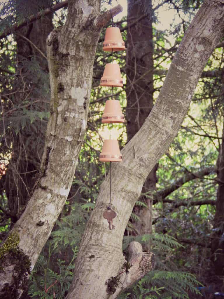 diy windchime with little pots hanging from a tree