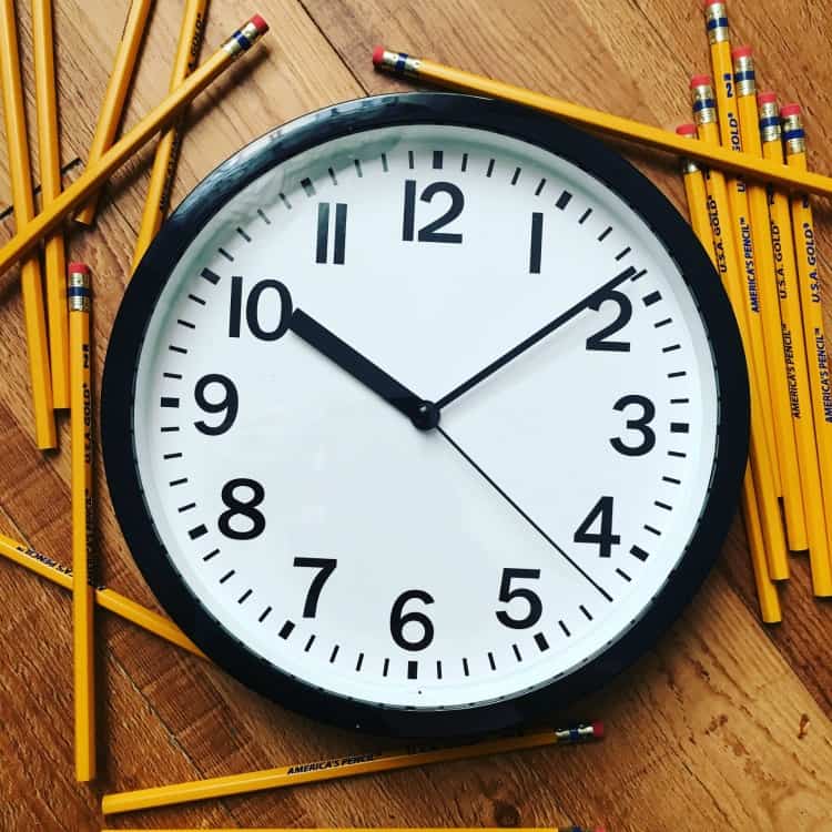 school clock with pencils around it