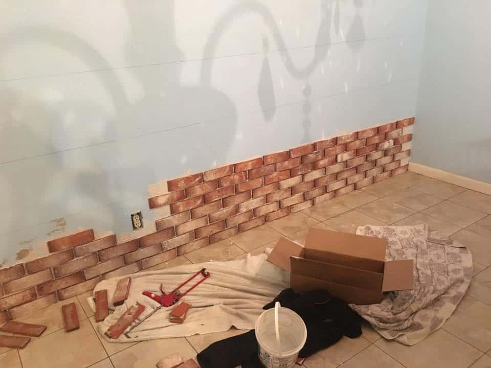 bricks adhered to the drywall with tile adhesive.