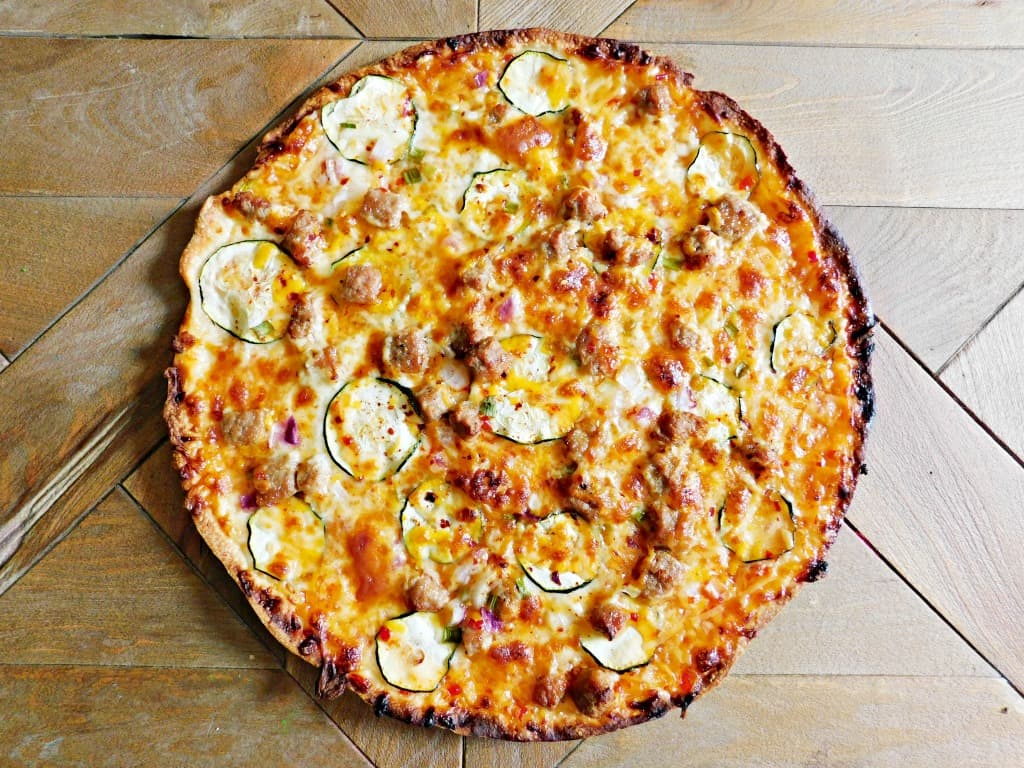 baked sweet chili pizza on wooden tabletop