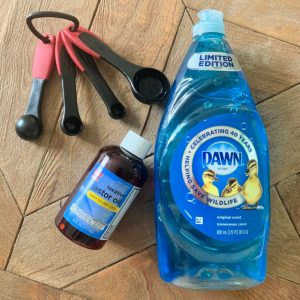 Dawn, castor oil and a measuring spoon on a table