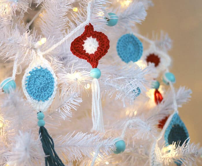 white christmas tree with crochet ornaments hanging from it