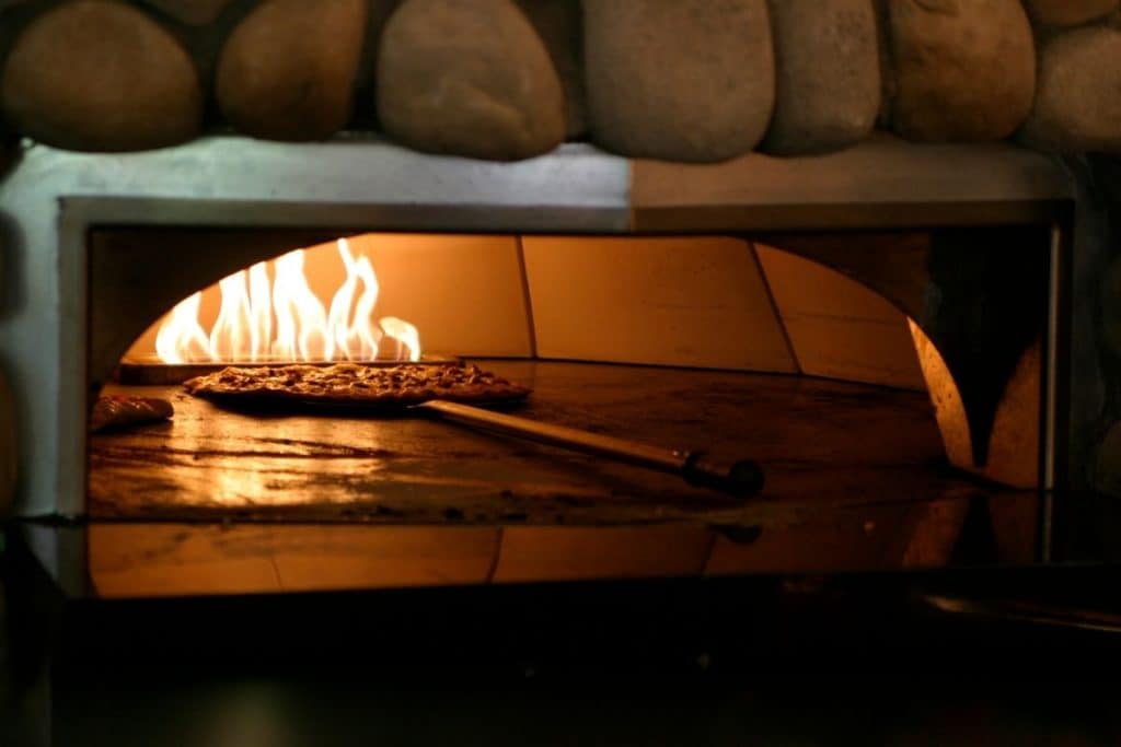 Pizza cooking inside a pizza oven.