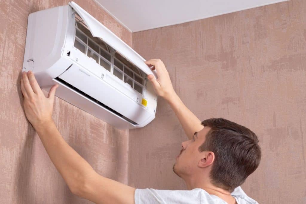 Man opening ac filter compartment.