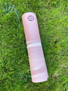 Lululemon yoga mat rolled up on grass outside