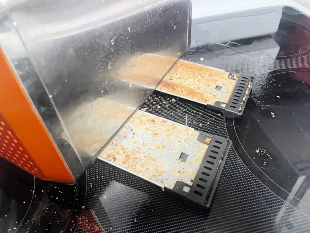 Dirty crumb trays from a toaster. 
