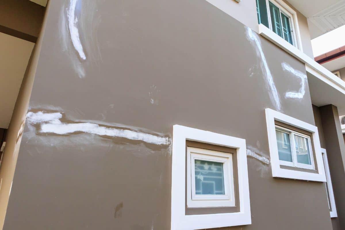 Brown wall with windows that has been freshly skim coated. 