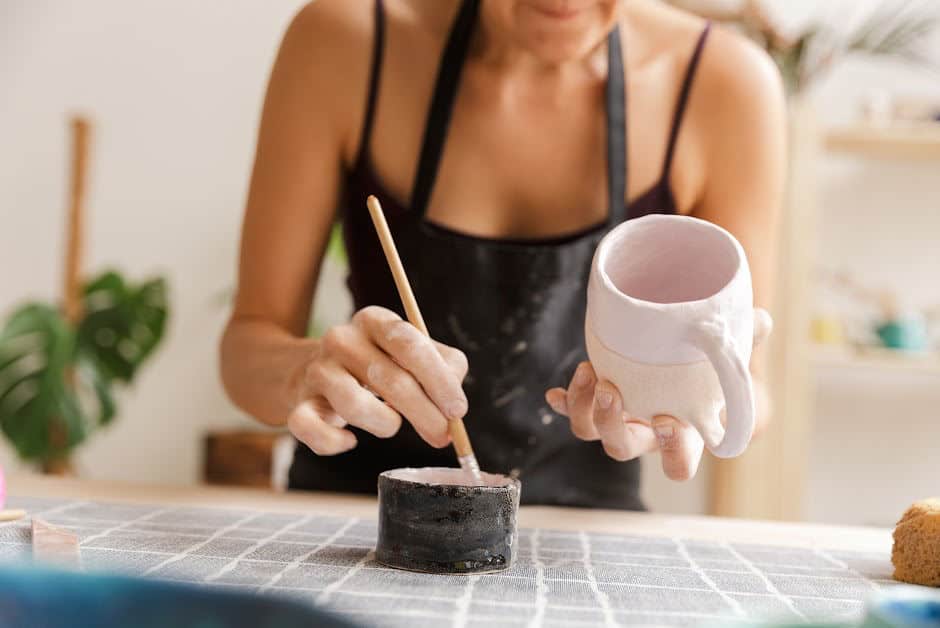 Woman painting mug with paint.
