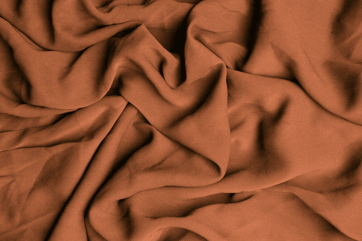 Close up of crumpled orange fabric. 