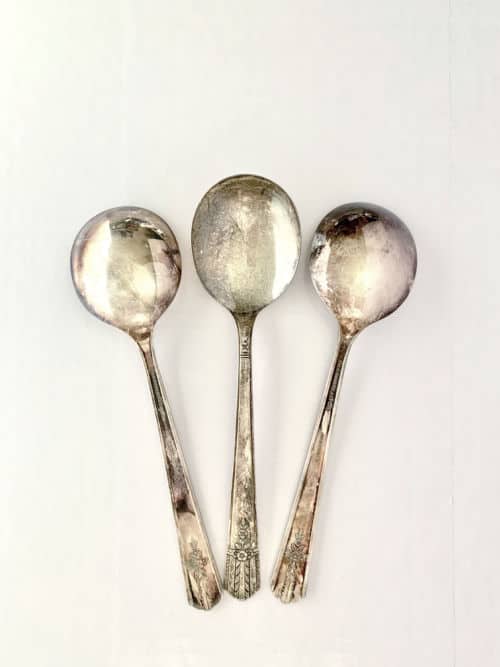 Three tarnished silver spoons ready to be cleaned with coke. 