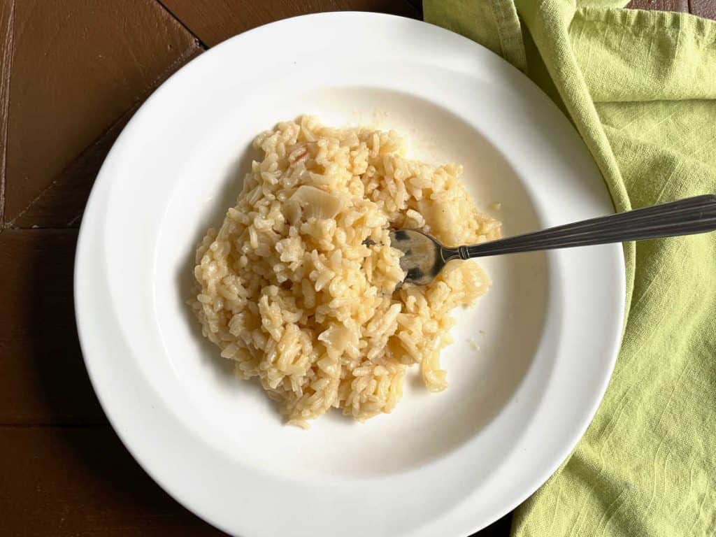 Traditional Italian risotto on a white plate with a green napkin. 
