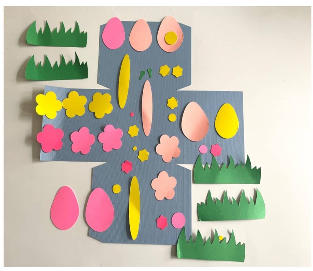 Pieces of the paper cut out for the Easter Basket laid out ready to be assembled. 