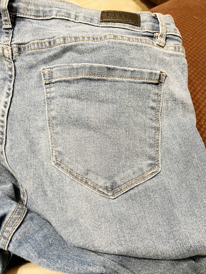 Close up of the back pocket of a pair of jeans that will be embroidered with a spider web.